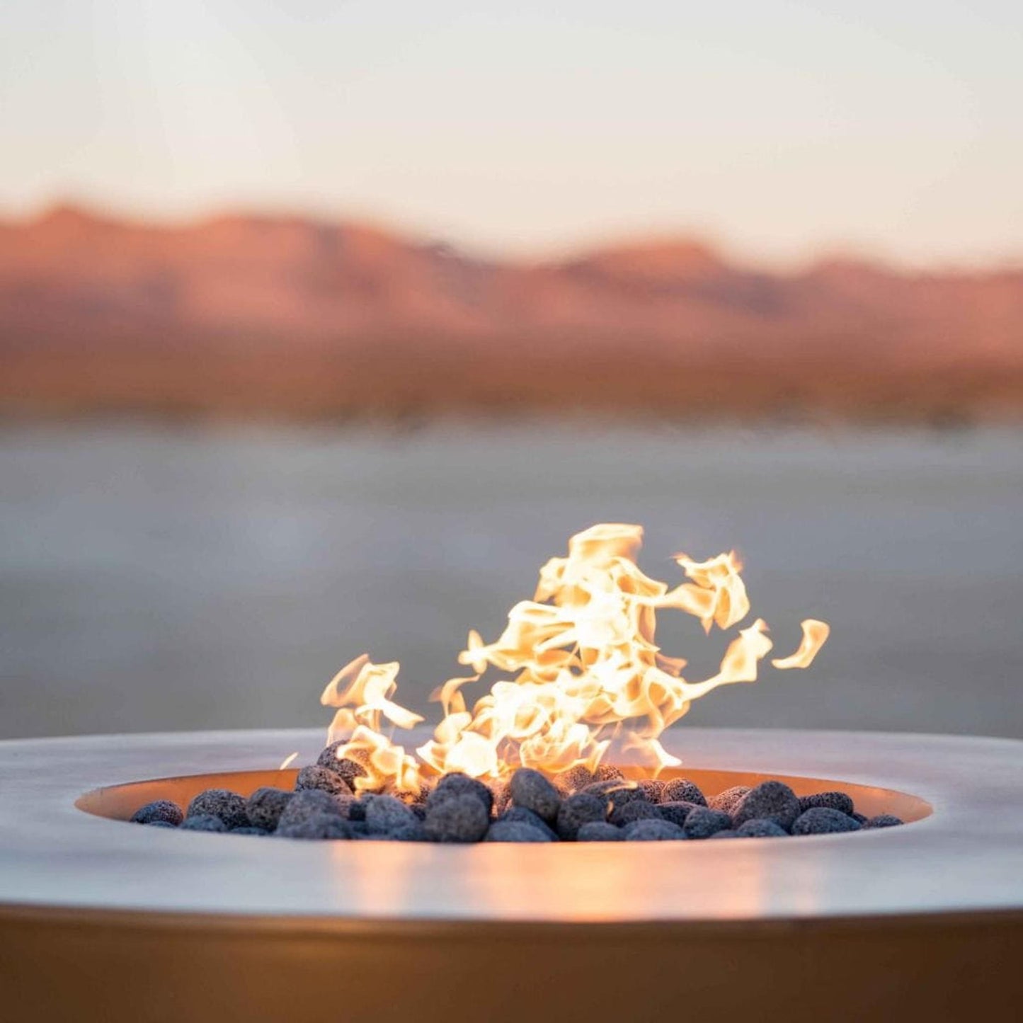 The Outdoor Plus 46" Outback Cattle Ranch GFRC Metallic/Rustic Top and Powdered Steel Base Round Liquid Propane Fire Table - Match Lit with Flame Sense